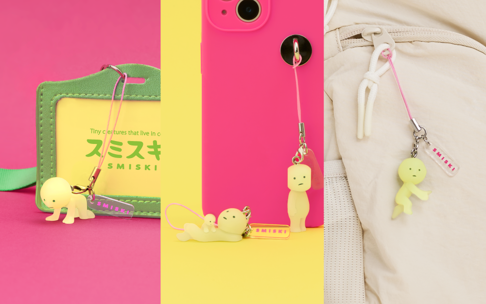 lifestyle images split three ways. left: SMISKI charm on a pink phone case with a green card holder in the background. middle" two smiski charms attached to a pink phone case on yellow background. right: smiski charm attached to the zipper of a jacket.