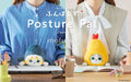 mofusand Posture Pal split image shows left: Shark Meow Posture Pal sat at a desktop in the lap of a figure with a blue striped shirt. Right side: set in the lap of a figure in a white shirt and tan vest, Shrimp Meow Posture Pal looks at the camera atop an open notebook
