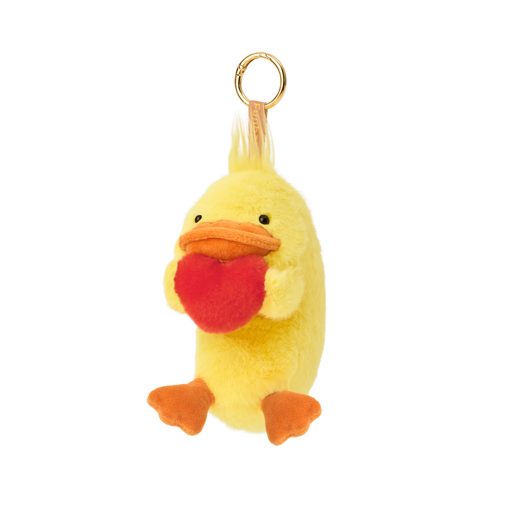 Product image shows Posture Pal Bag Charm, Duck variant with a brown tag and gold circle clip. Duck is bright yellow and orange colored, holding a red plush heart between its hands.