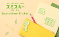 SMISKI Embroidery Sticker text set on wooden background with green paperclips, yellow pencil pouch with Pushing SMISKI sticker on left side. Red pencil poking out of pouch, with tan folder and Peeking 2, and Little variants atop a green folder.